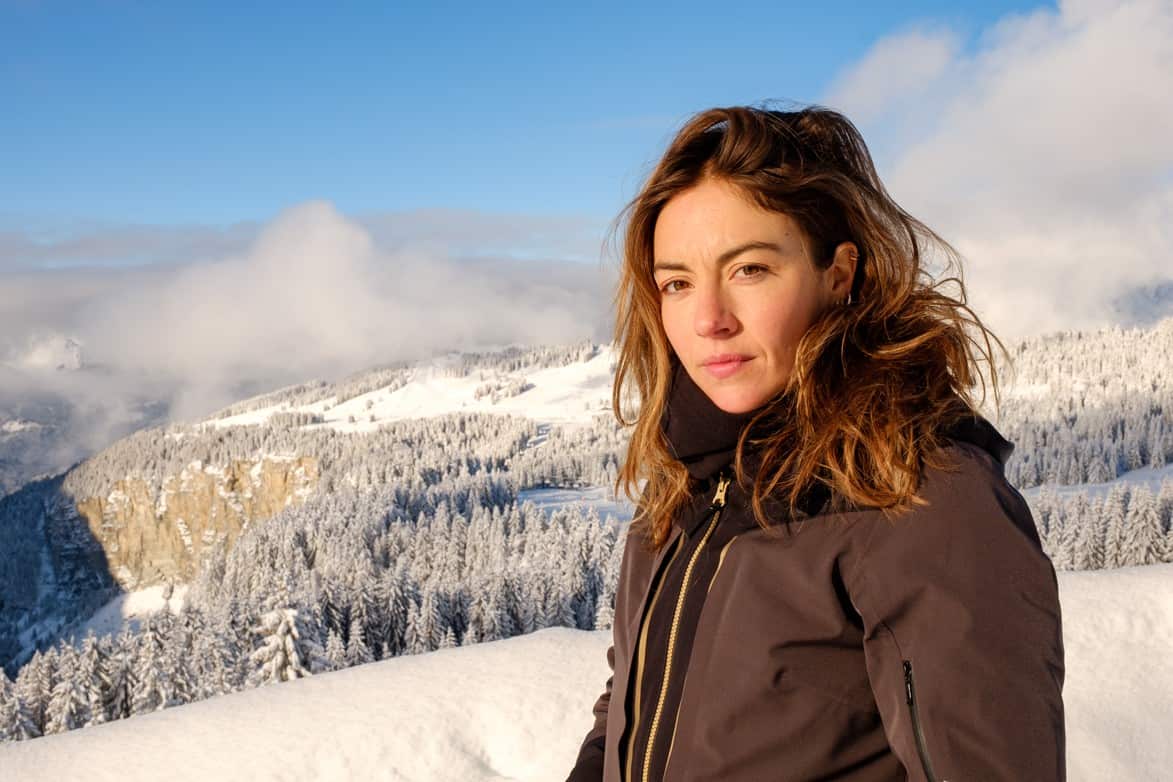 A woman stands on a snowy mountain