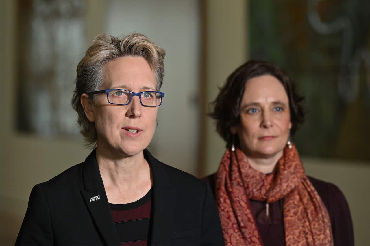 Two people stand at a press conference