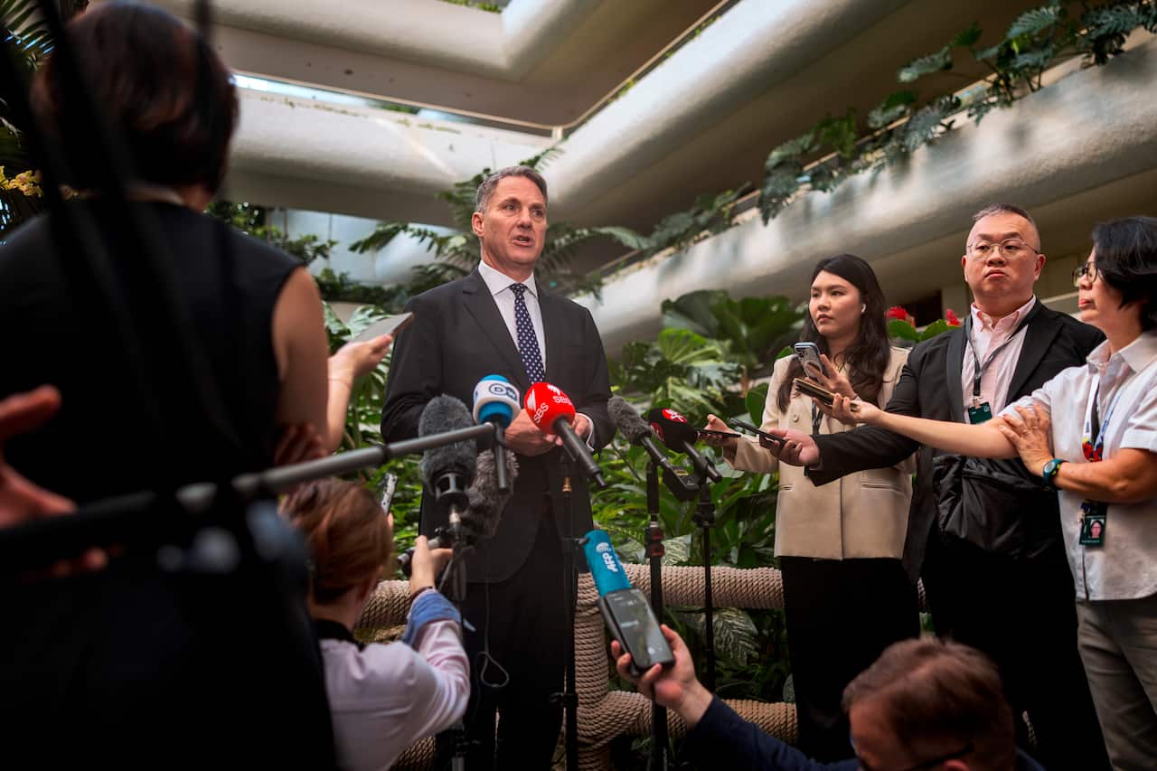 Richard Marles speaks to reporters in a plant-lined building in Singapore.