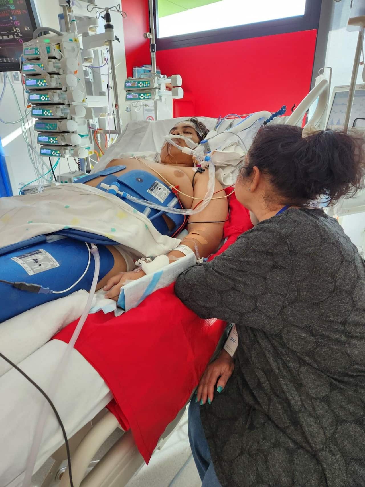 A family member beside the hospital bed of Cassius Turvey in Perth Children's Hospital
