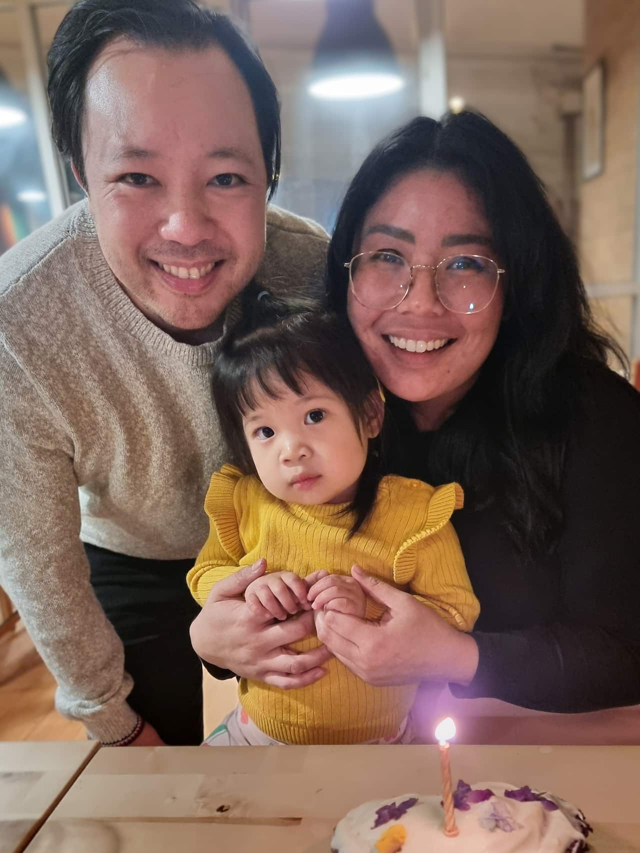 Two adults and a children smile for a photo. 