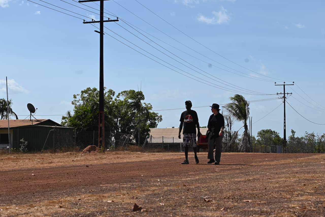 Wurankuwu Traditional Owner Ron Poantimilui walks the empty streets of his community with NITV Reporter Emma Kellaway