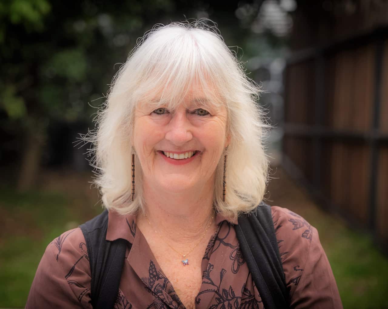 Death cafe facilitator Melissa Halliday sitting in a garden.