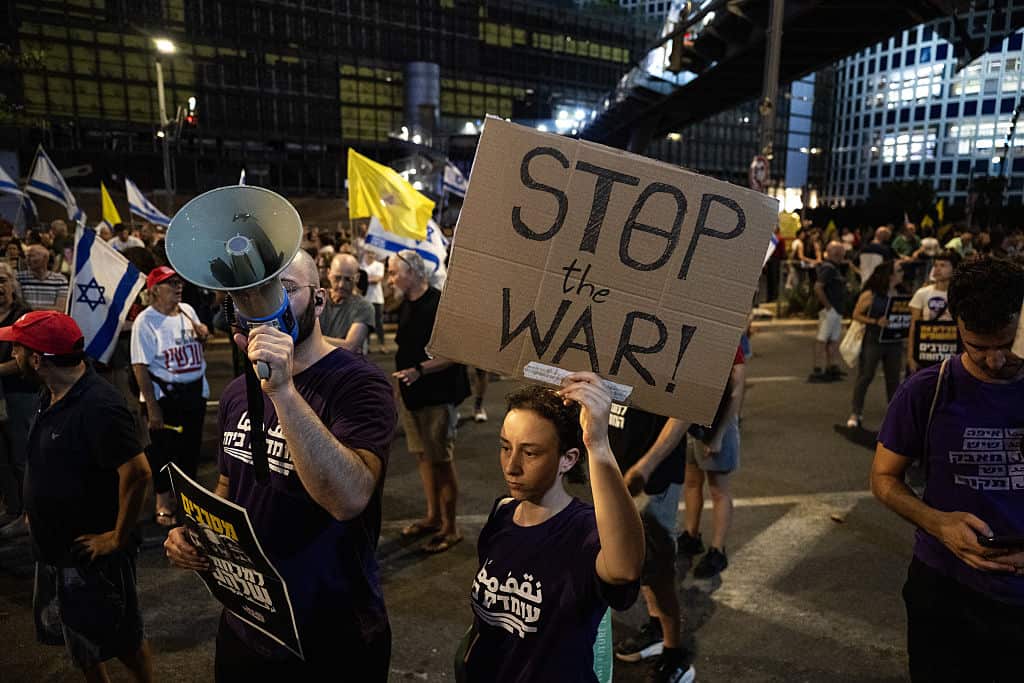  A group of Israeli demonstrators, carrying photos of captives and anti-government banners
