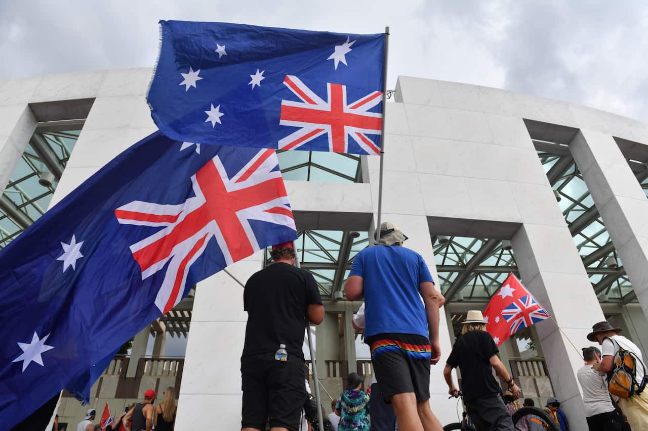 Men holding upside down Australian flags.