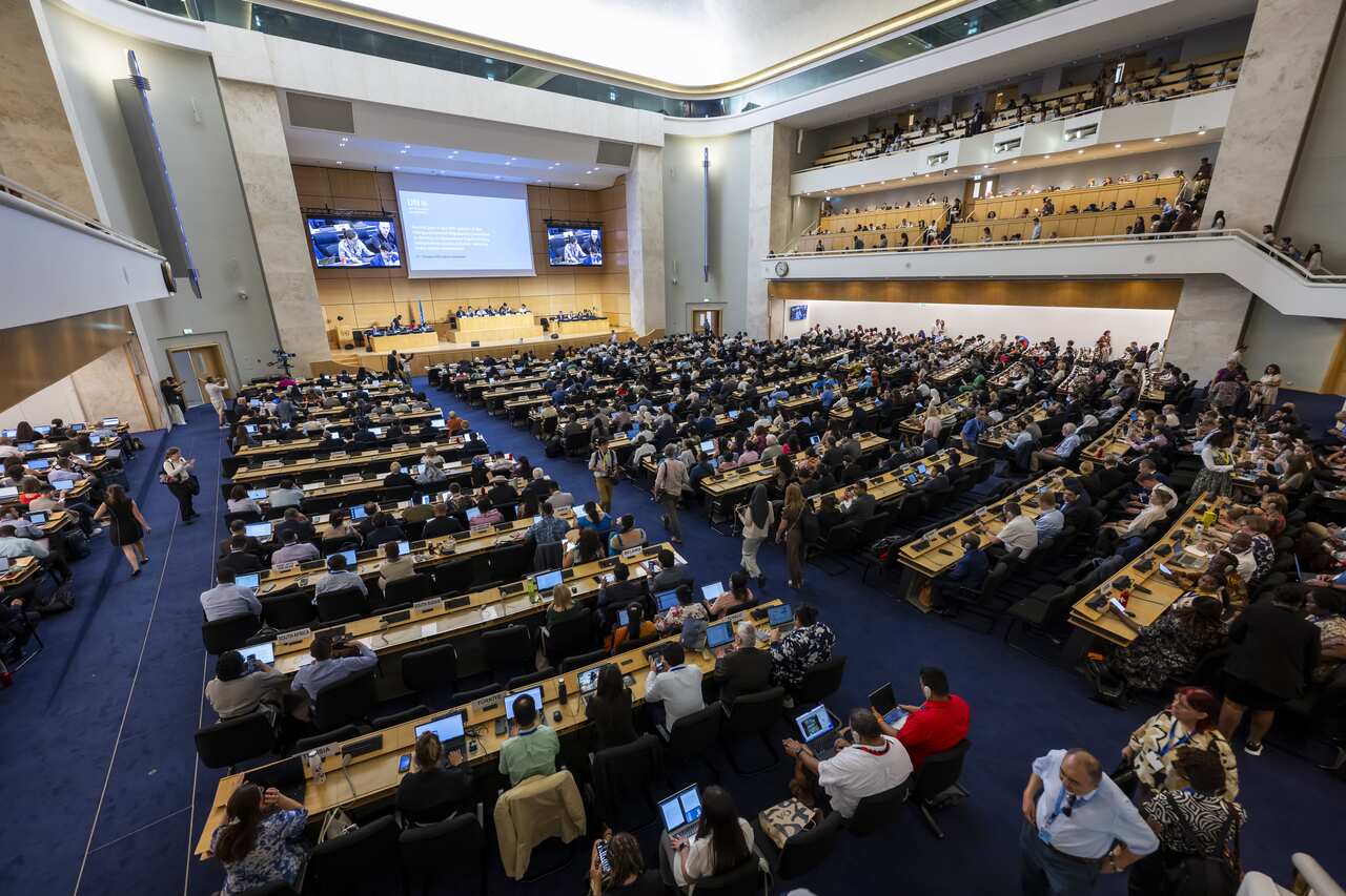 A large group of people in a room sitting and looking at a stage