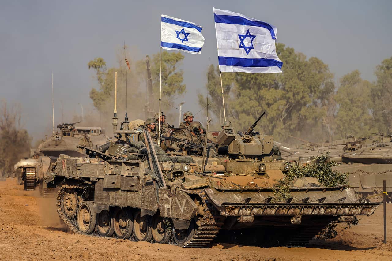 Israeli army vehicles arrive to an staging area after combat in the Gaza Strip.