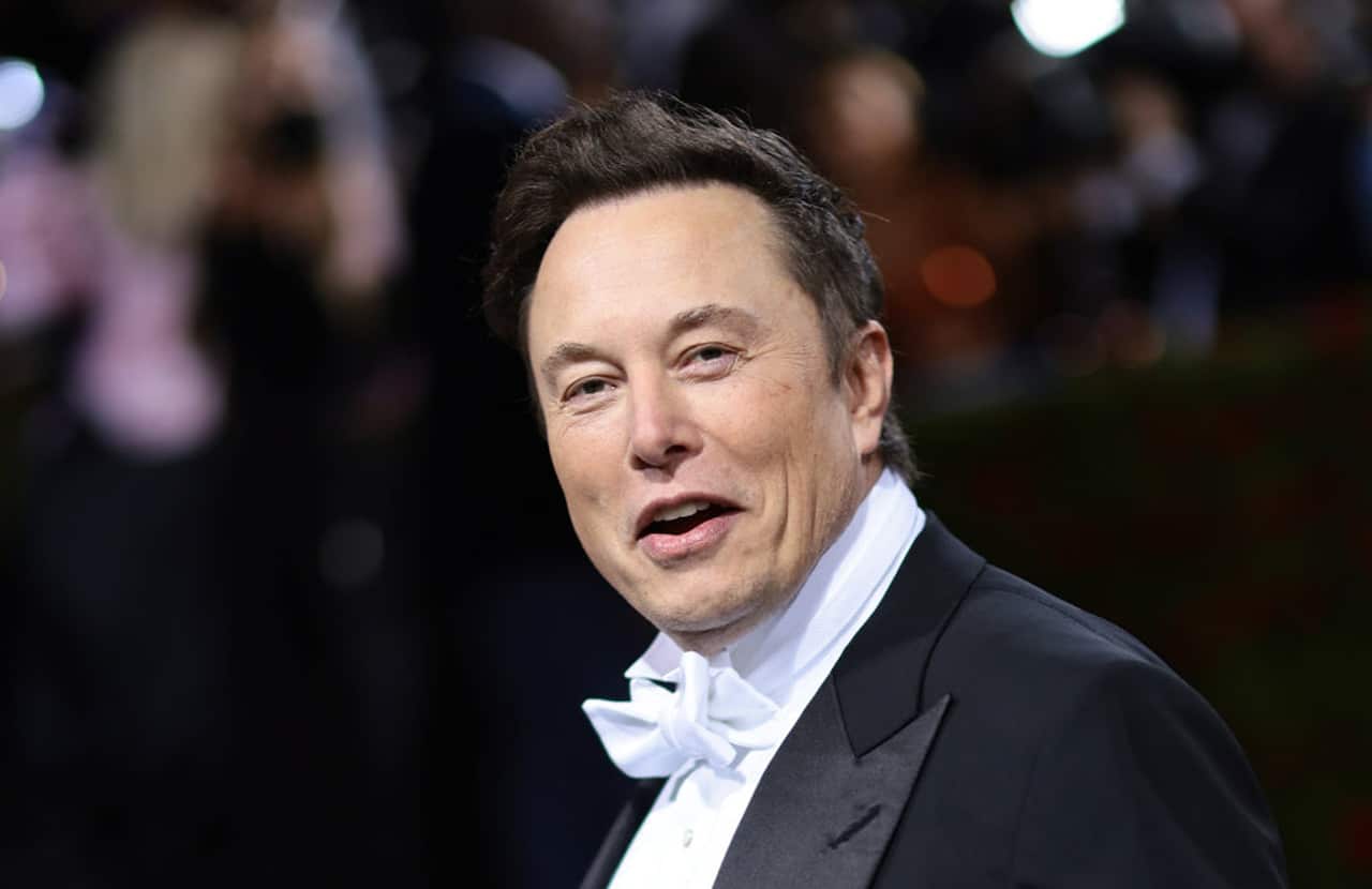 Elon Musk wearing a black suit coat and white shirt and bow tie