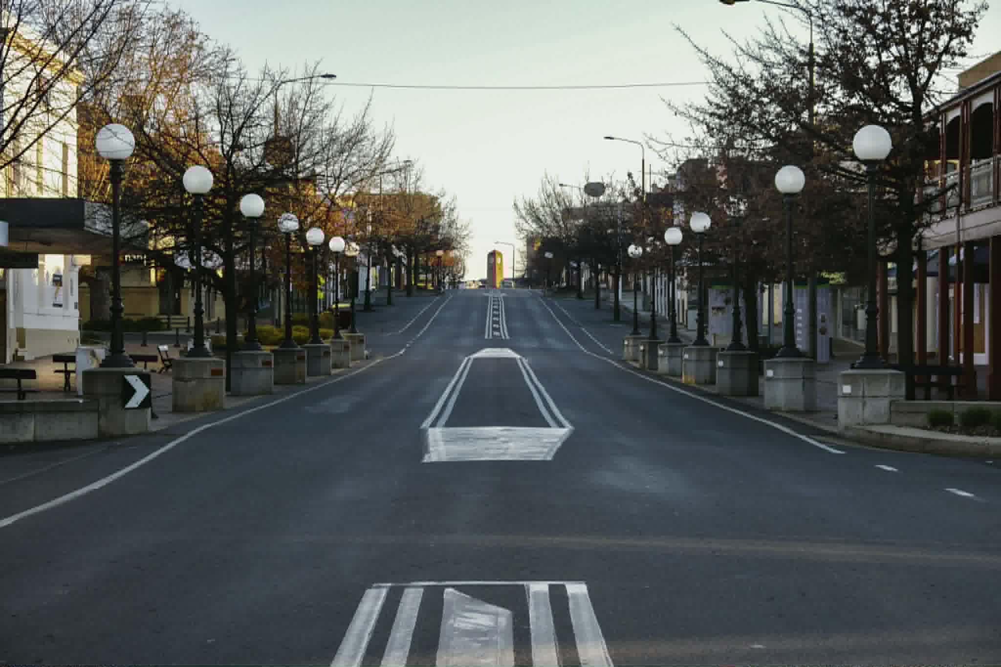 A street lined with lamposts and trees 