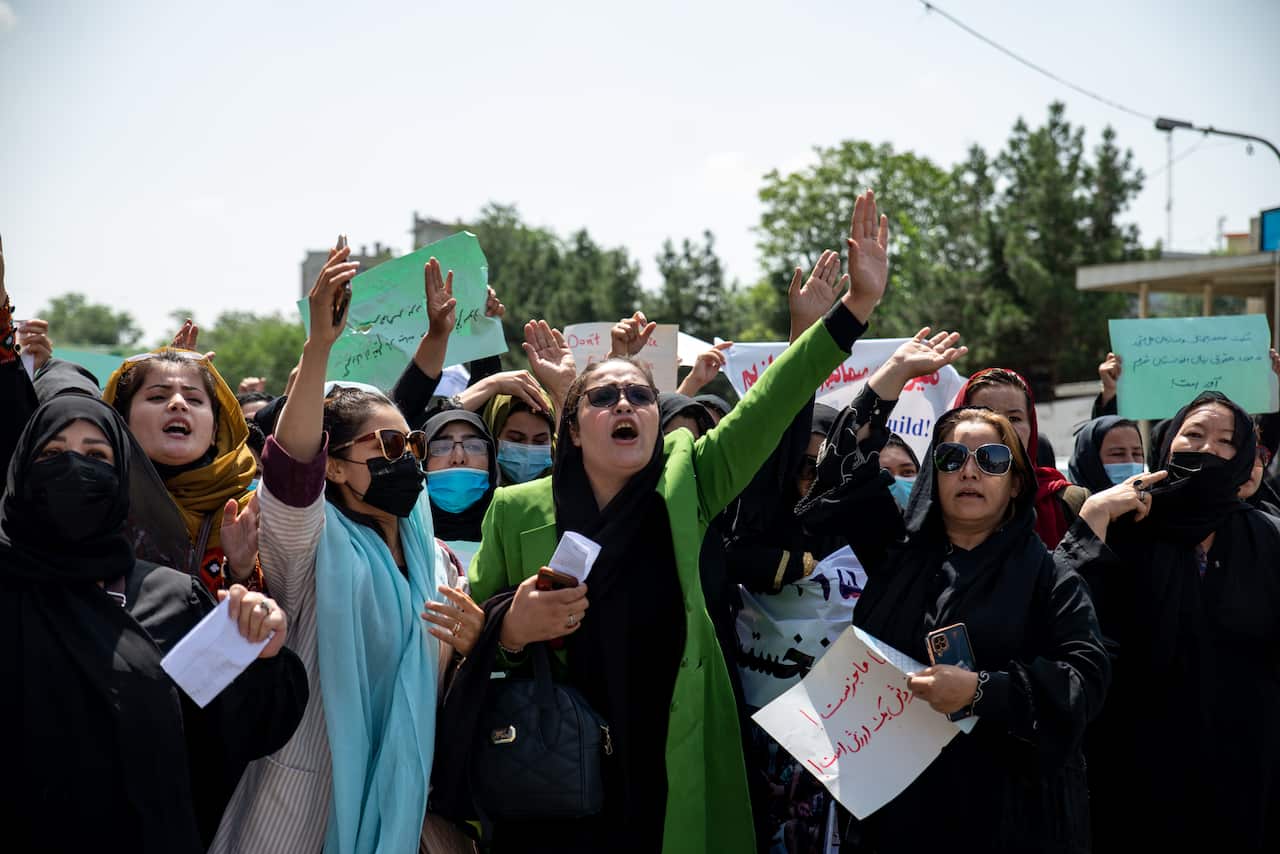 Woman chanting and holding signs.