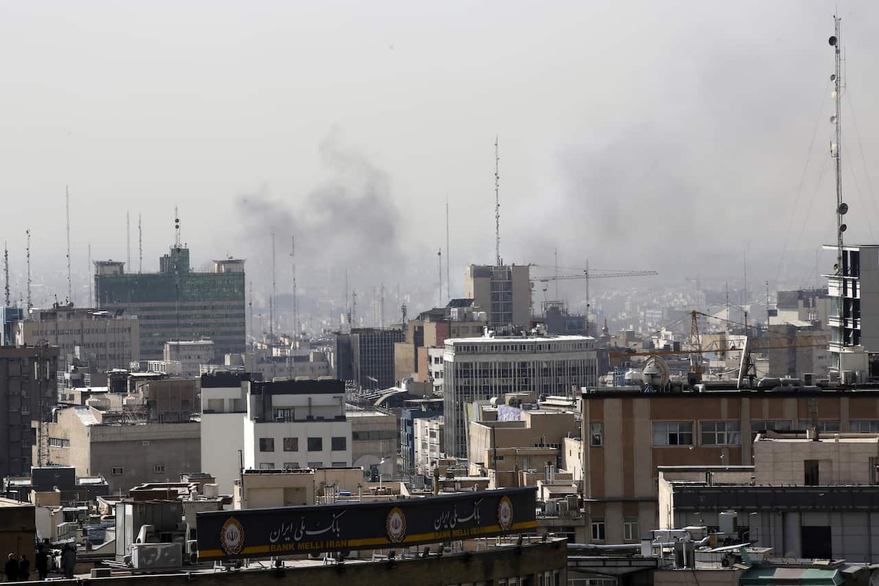Smoke rises above a city.
