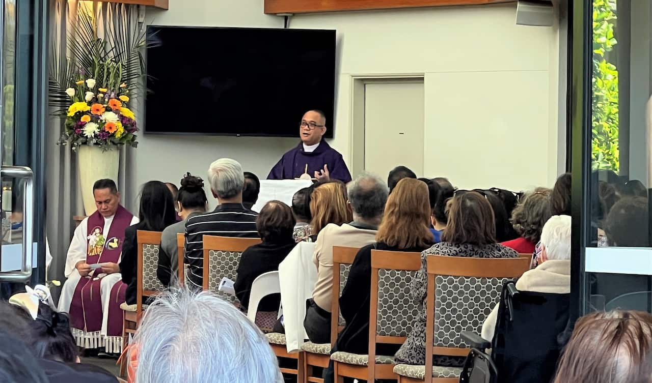 Reverend Reginaldo Lavilla leading the church service, with 10 other Filipino priests, at the Pinegrove Memorial Park service.