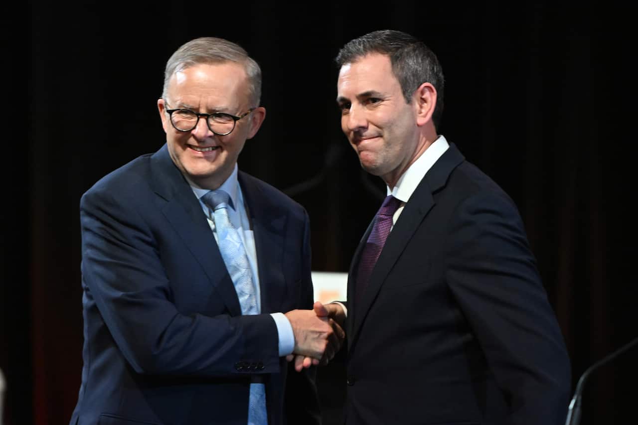 Prime Minister Anthony Albanese and Treasurer Jim Chalmers standing and shaking hands.