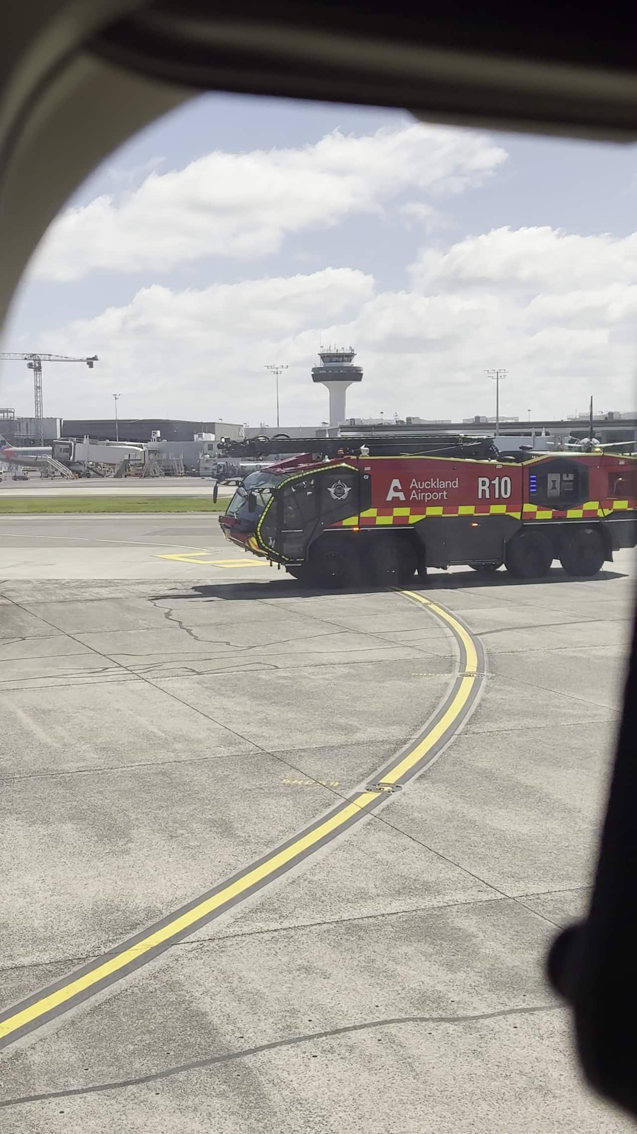 An emergency services vehicle on the tarmac next to a plane.