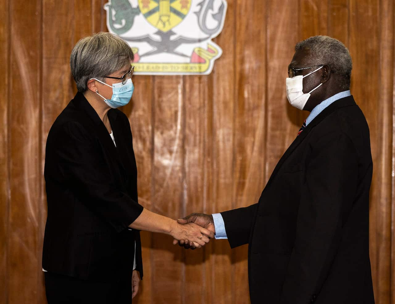 Australian Foreign Minister Penny Wong shakes hands with Solomon Islands Prime Minister Manasseh Sogavare.