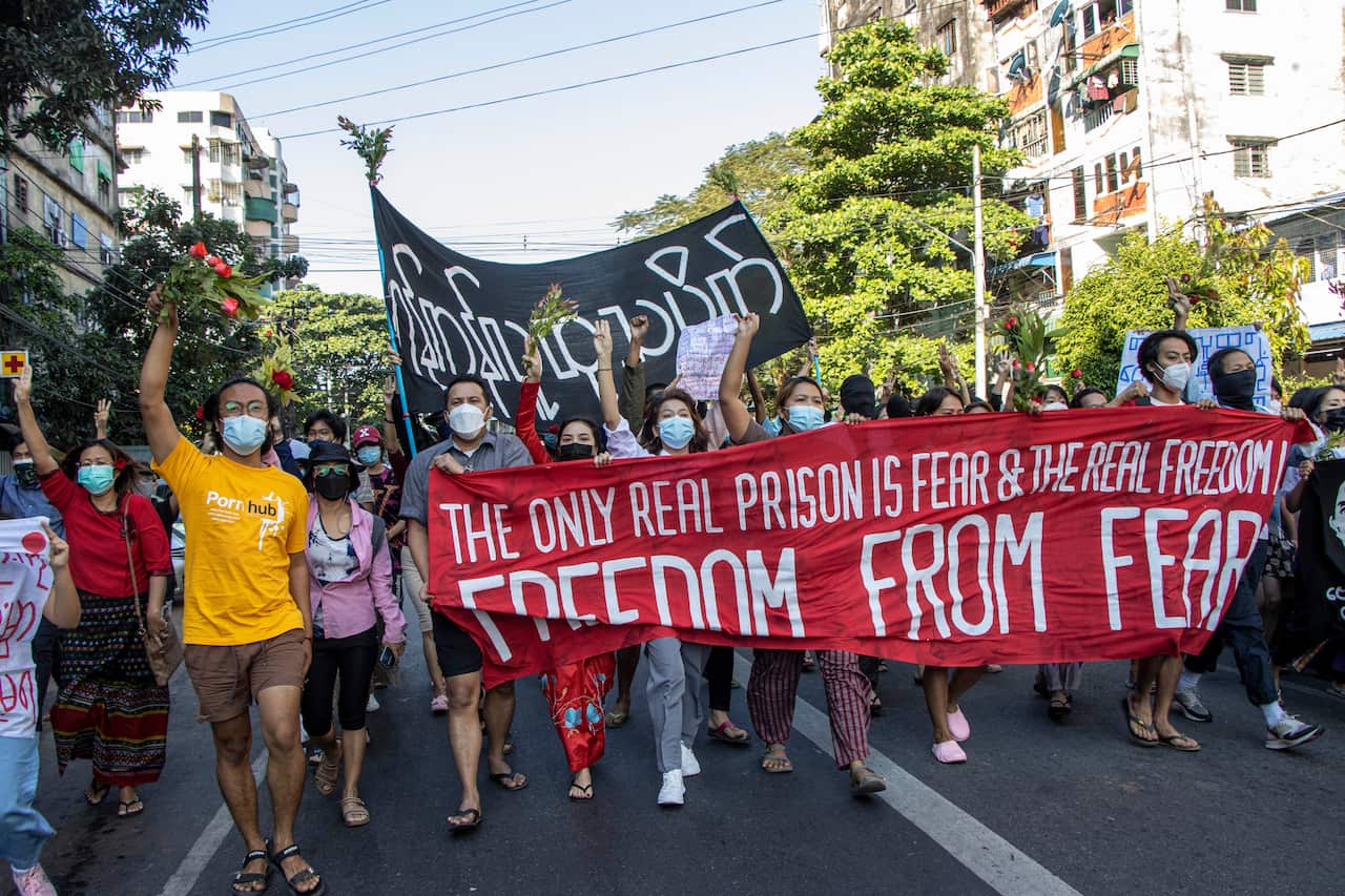 Protesting marching. Some are holding a banner that reads: "FREEDOM FROM FEAR".