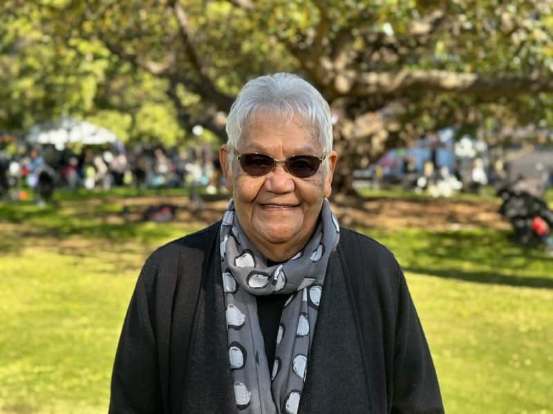 Aunty Lorraine wears a grey scarf and a black jumper at the Royal Botanic Gardens. 