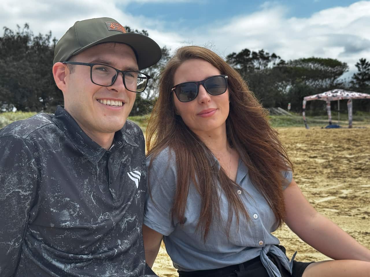 A man and woman sitting together on the beach.