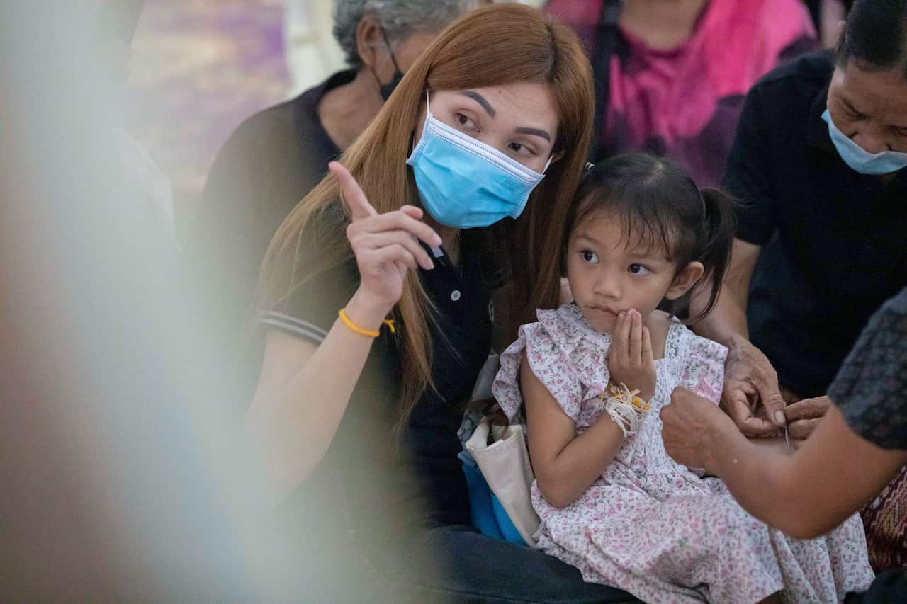 A toddler sitting on a woman's lap