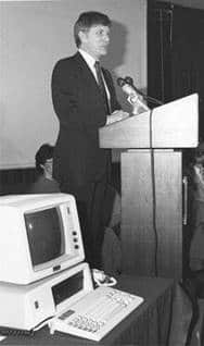 A black and white photo of a man standing at a lectern