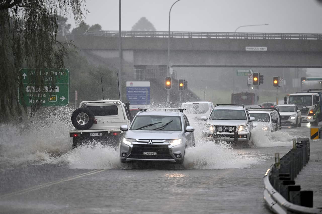 People driving cars in heavy rain.