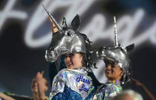 Dancers wearing sparkly silver unicorn helmets on their heads.