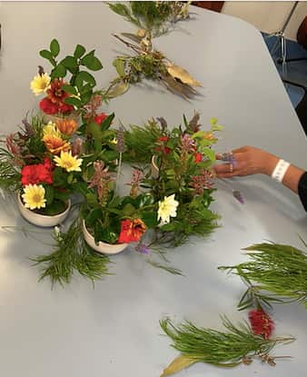 團體花藝作品：院友正在將花旗(Floral Garland)作品從直線排列改為圓形。