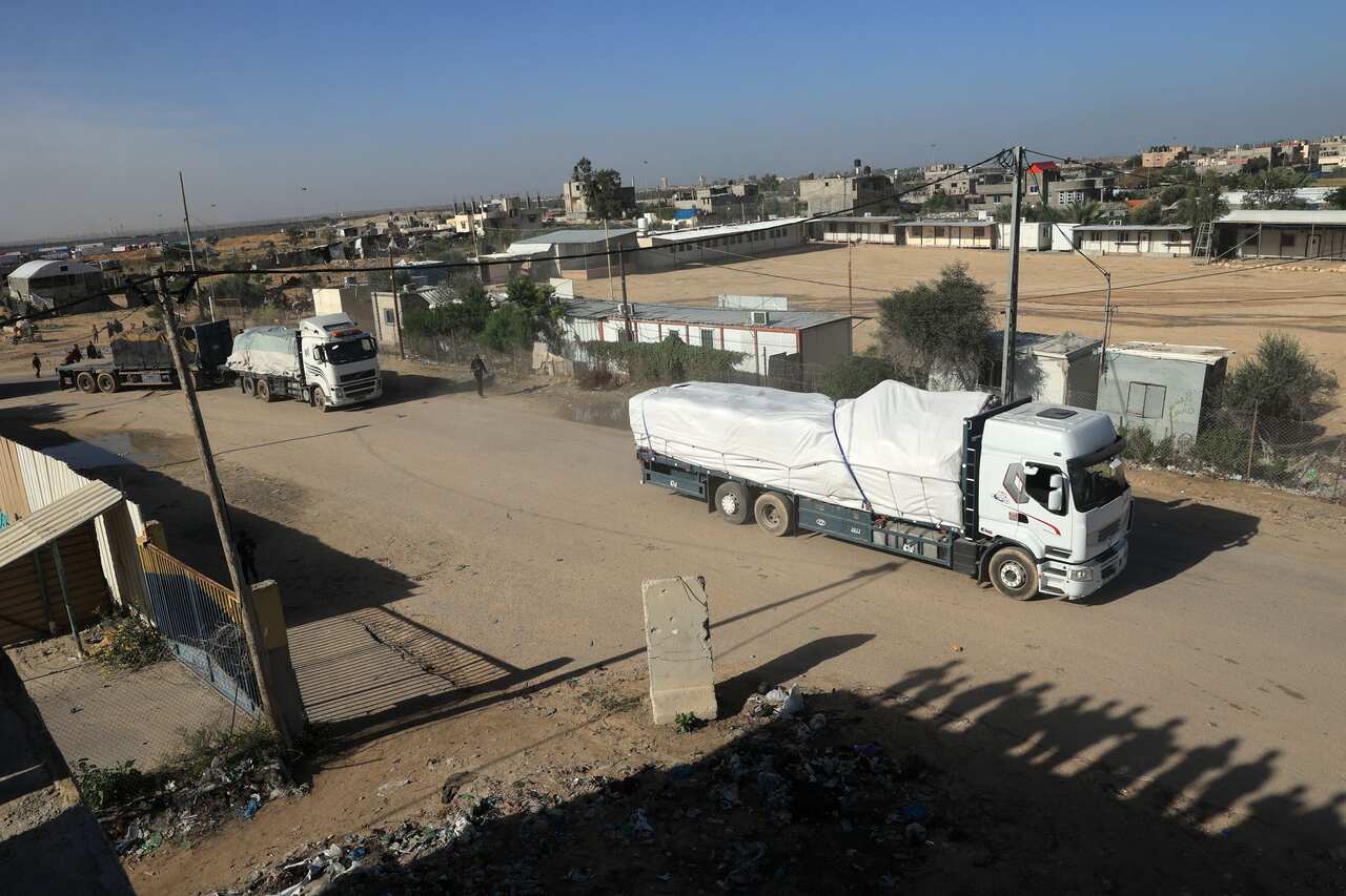 Trucks being driven along a dirt road.