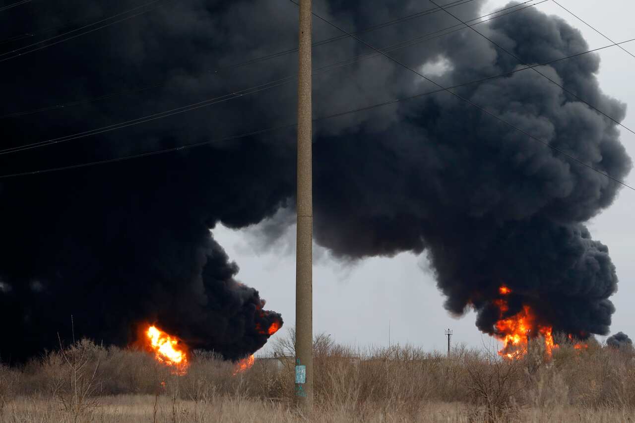 Smoke rises over an oil depot hit by fire.