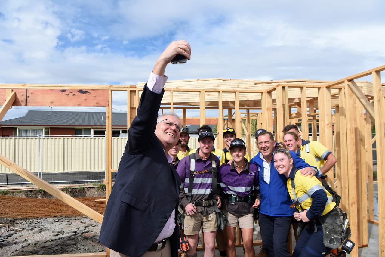 Prime Minister Scott Morrison takes a selfie with Liberal member for Braddon Gavin Pearce and apprentices on a building site in Spreyton, Tasmania on 3 April 2022.  