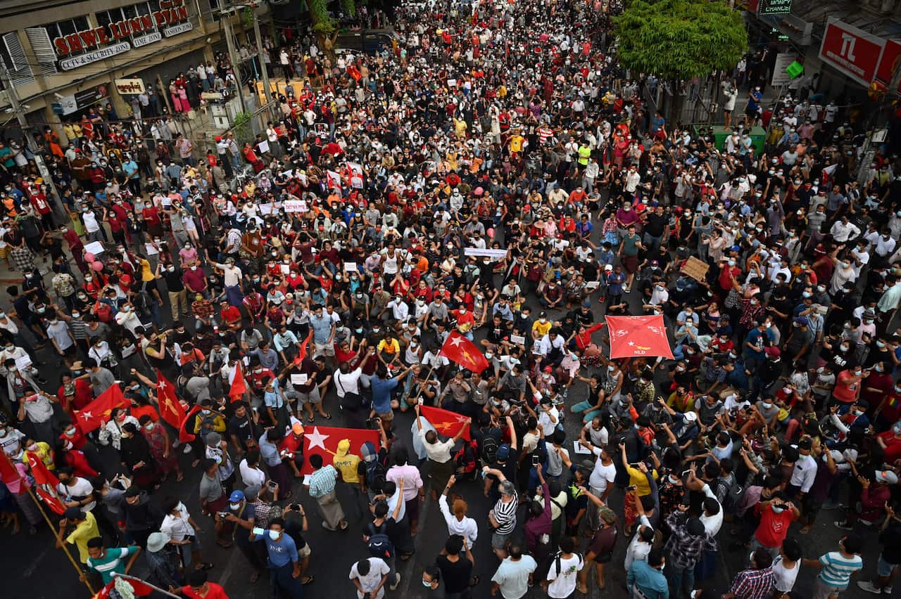 Large crowds of people holding flags and banners on the street