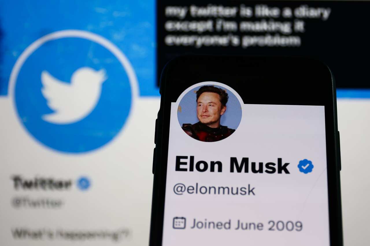 Elon Musk account on Twitter displayed on a phone screen and Twitter account on Twitter displayed on a laptop screen
