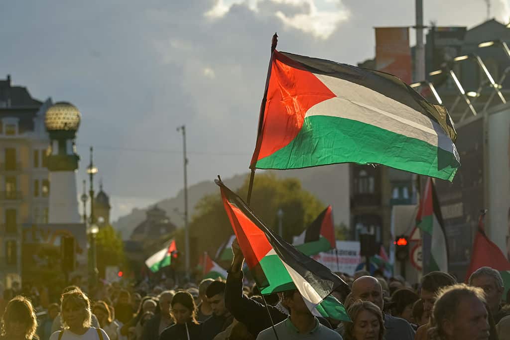 Activists wave Palestinian flags at a protest march.