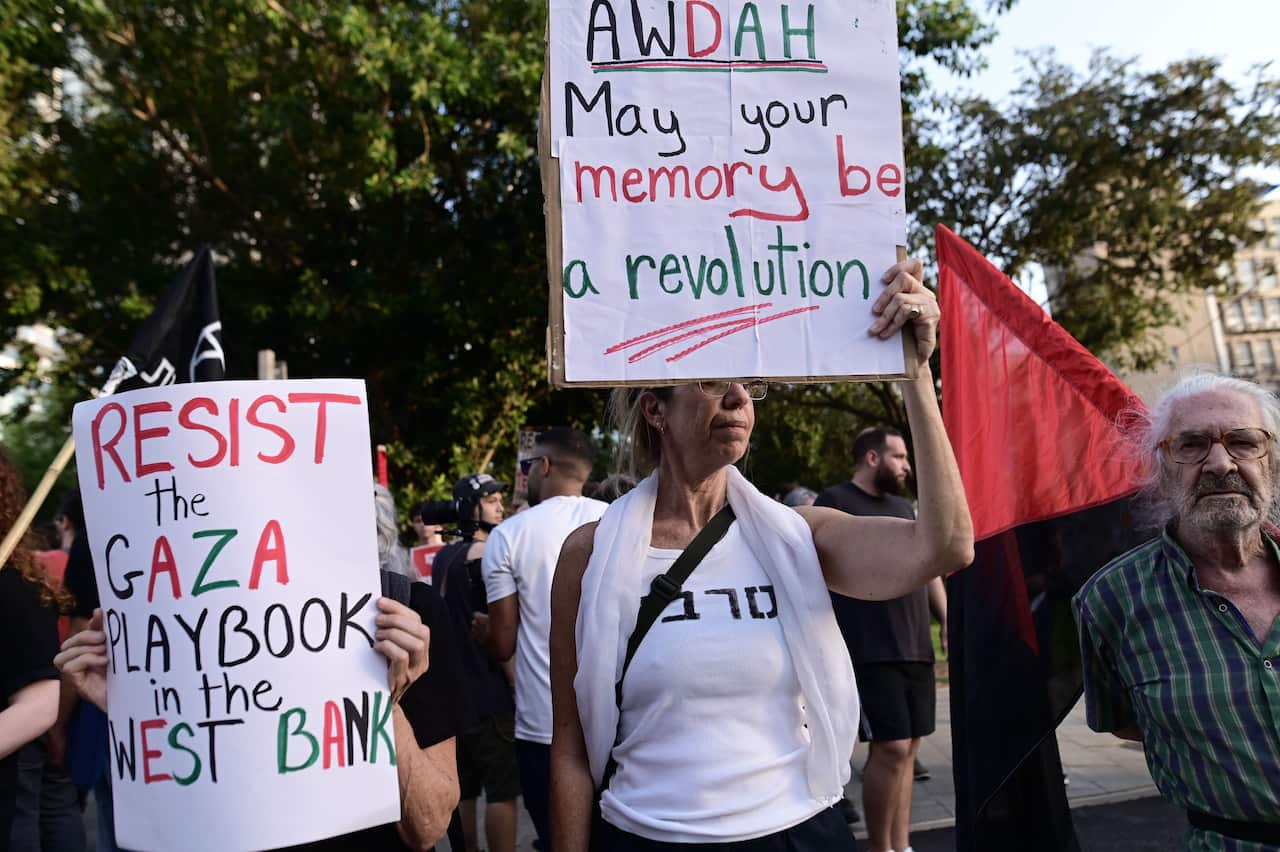 People hold up signs at a demonstration