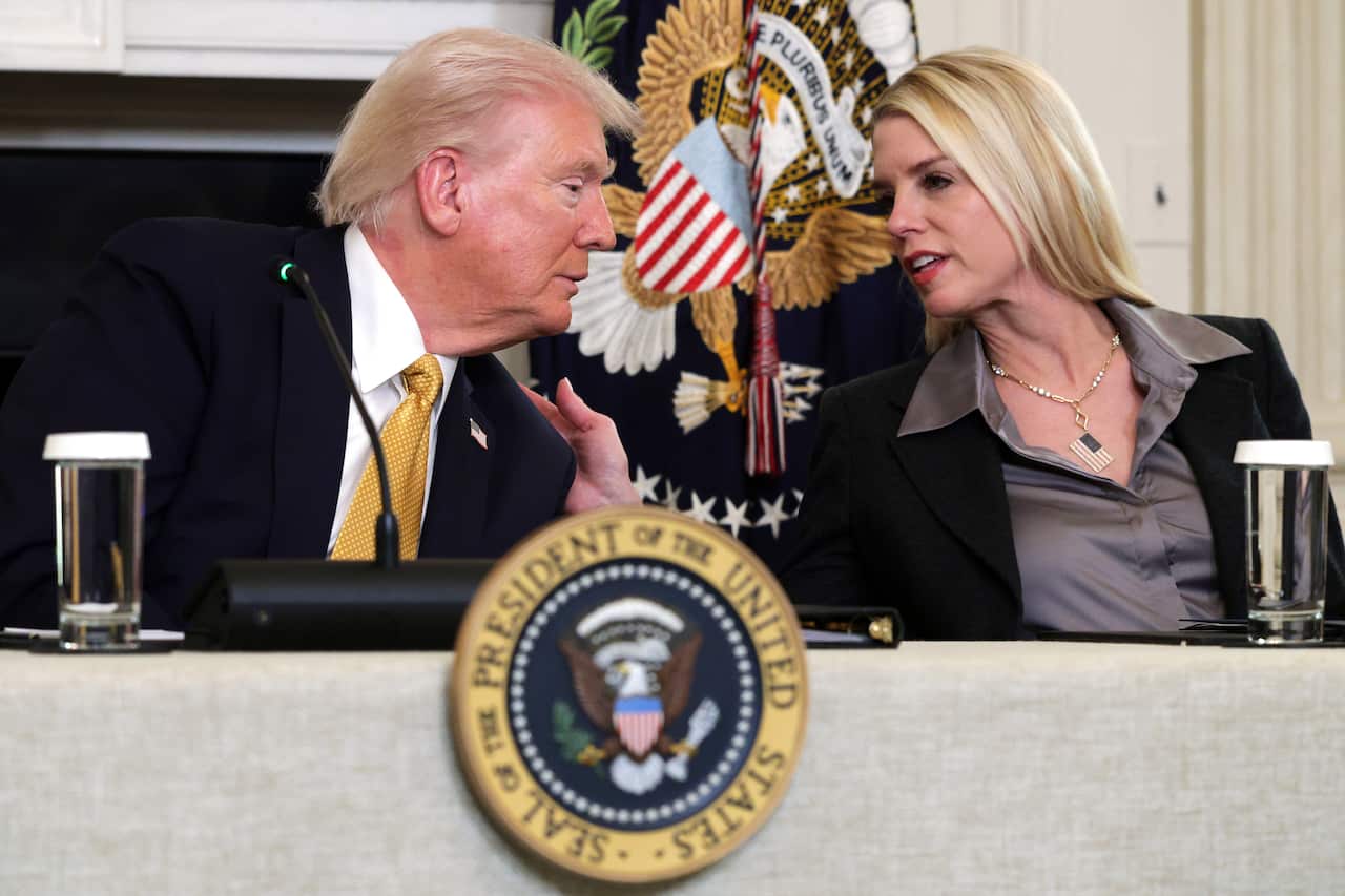 President Trump leaning over and speaking with his Attorney General Pam Bondi.