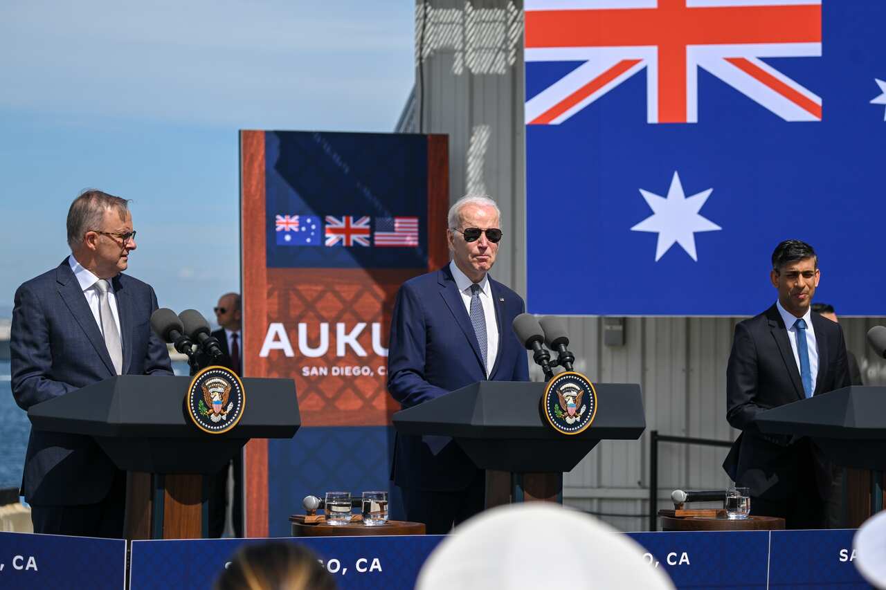 Joe Biden, Anthony Albanese and Rishi Sunak stand at podiums