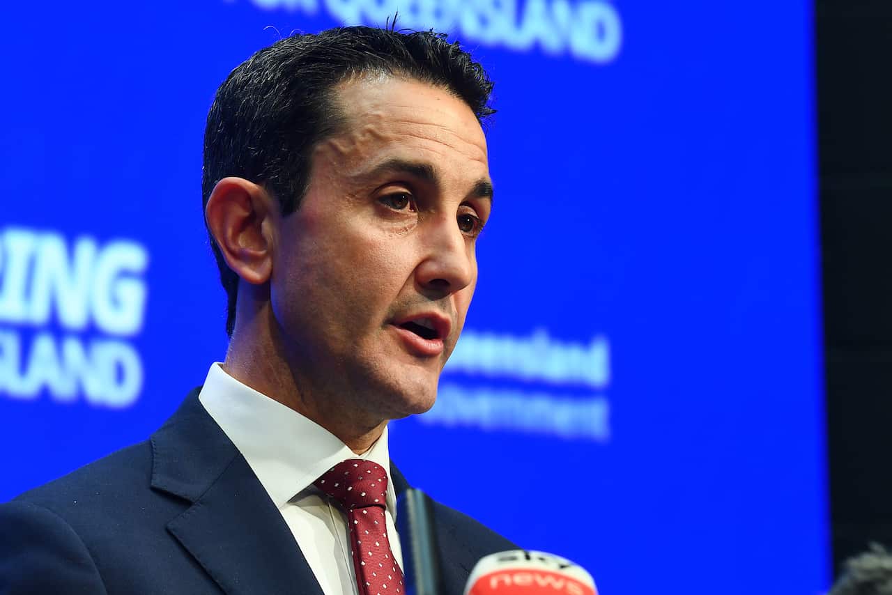 David Crisafulli standing in front of a blue background.