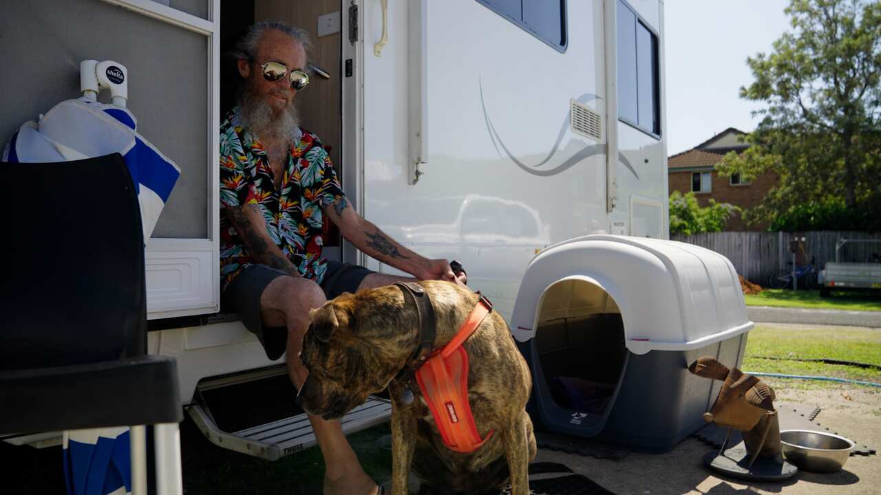William Gallagher and his dog Shelby outside his caravan in Ballina.