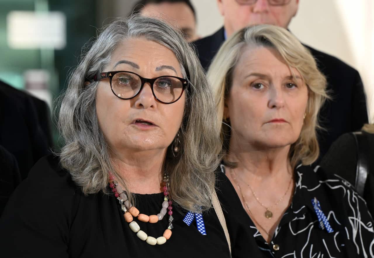 Two women standing together outside 