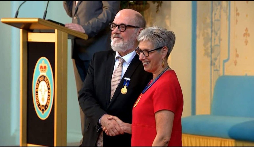 Tim Thorpe receiving his OAM from former General Governor of Victoria Linda Dessau.