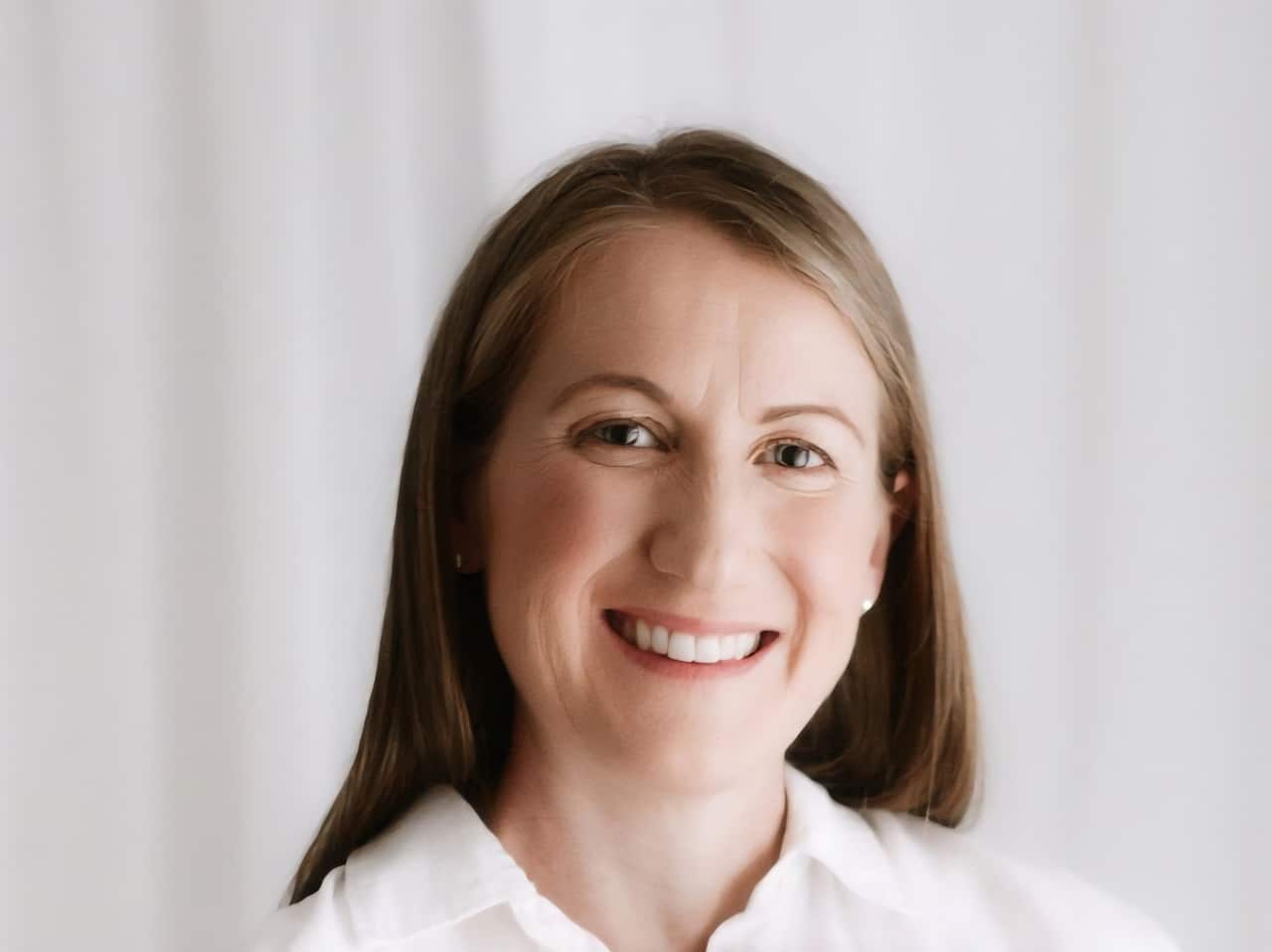A portrait picture of a woman with long hair smiling at the camera.