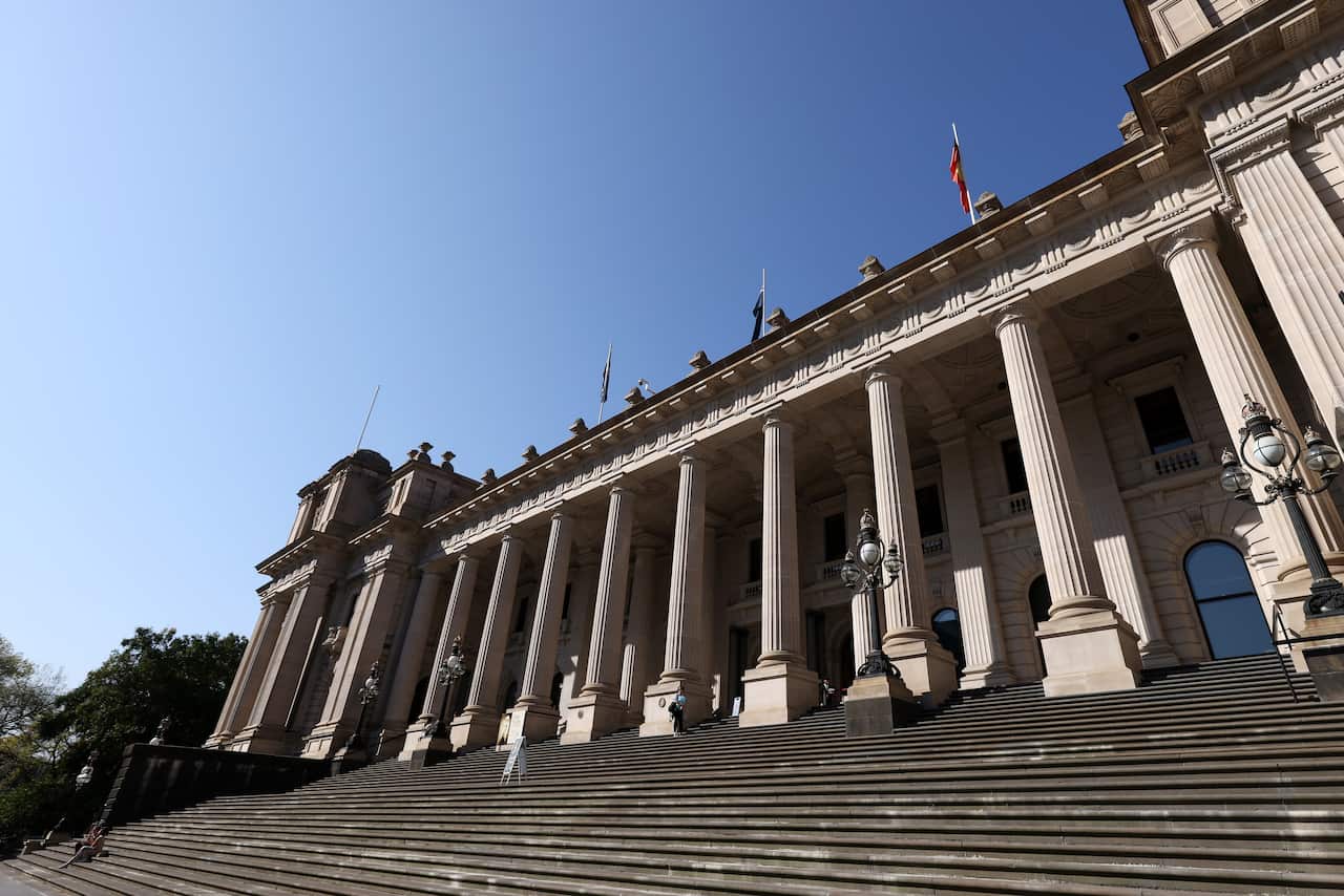 The outside steps of a large white-coloured building whose frontage includes a number of large columns. 