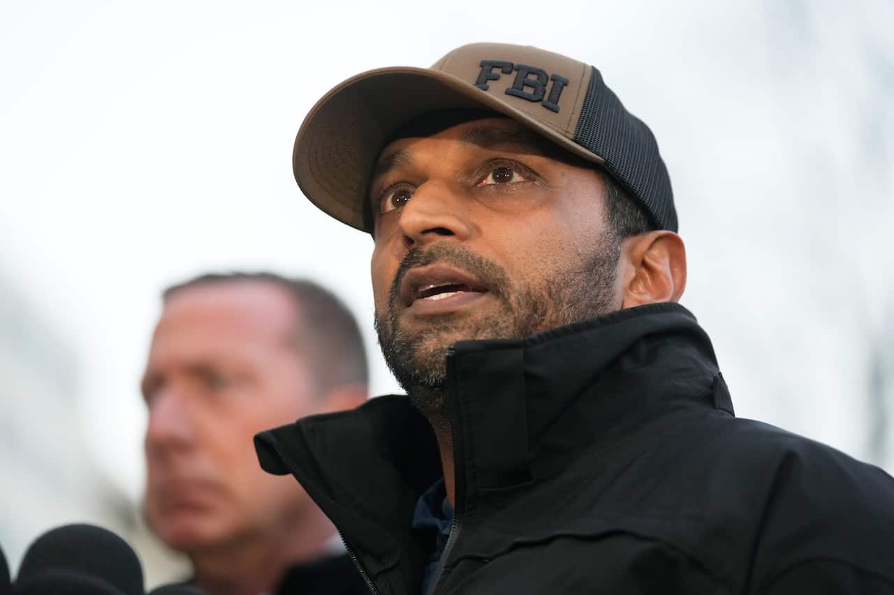 A man wearing a black jacket and a hat that says "FBI".