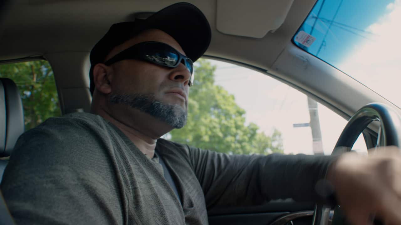A man with sunglasses driving.
