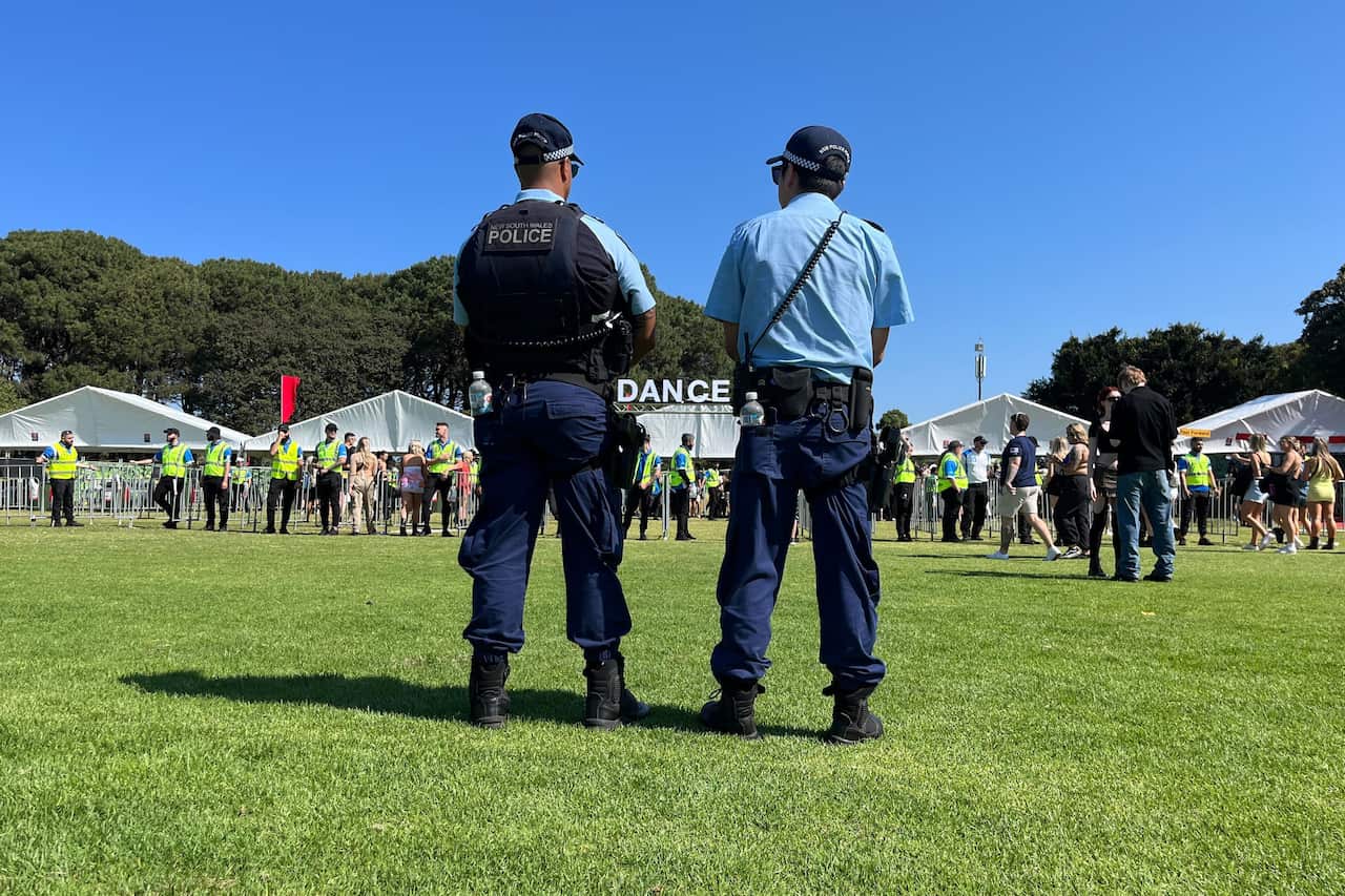 Two police standing observing an outdoor music festival