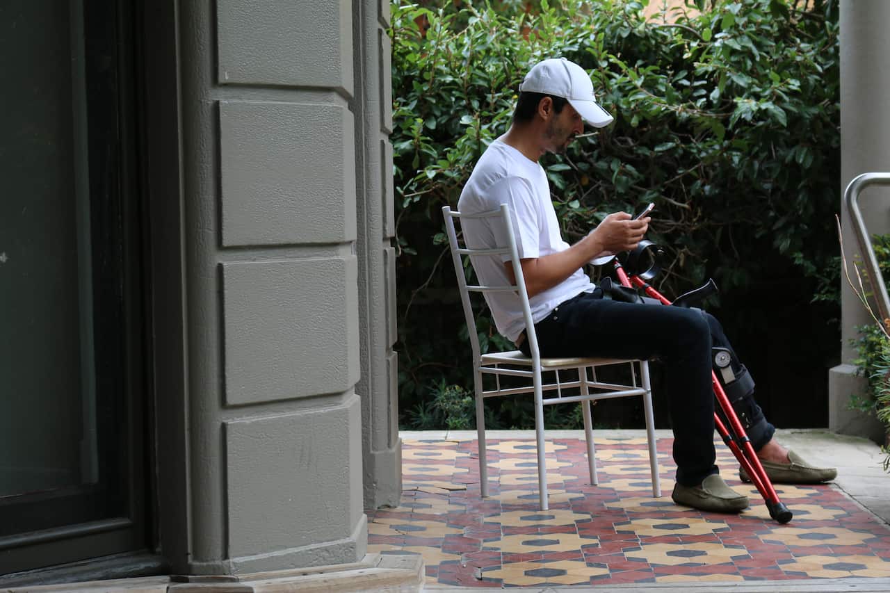 Man sitting on chair looking at his phone
