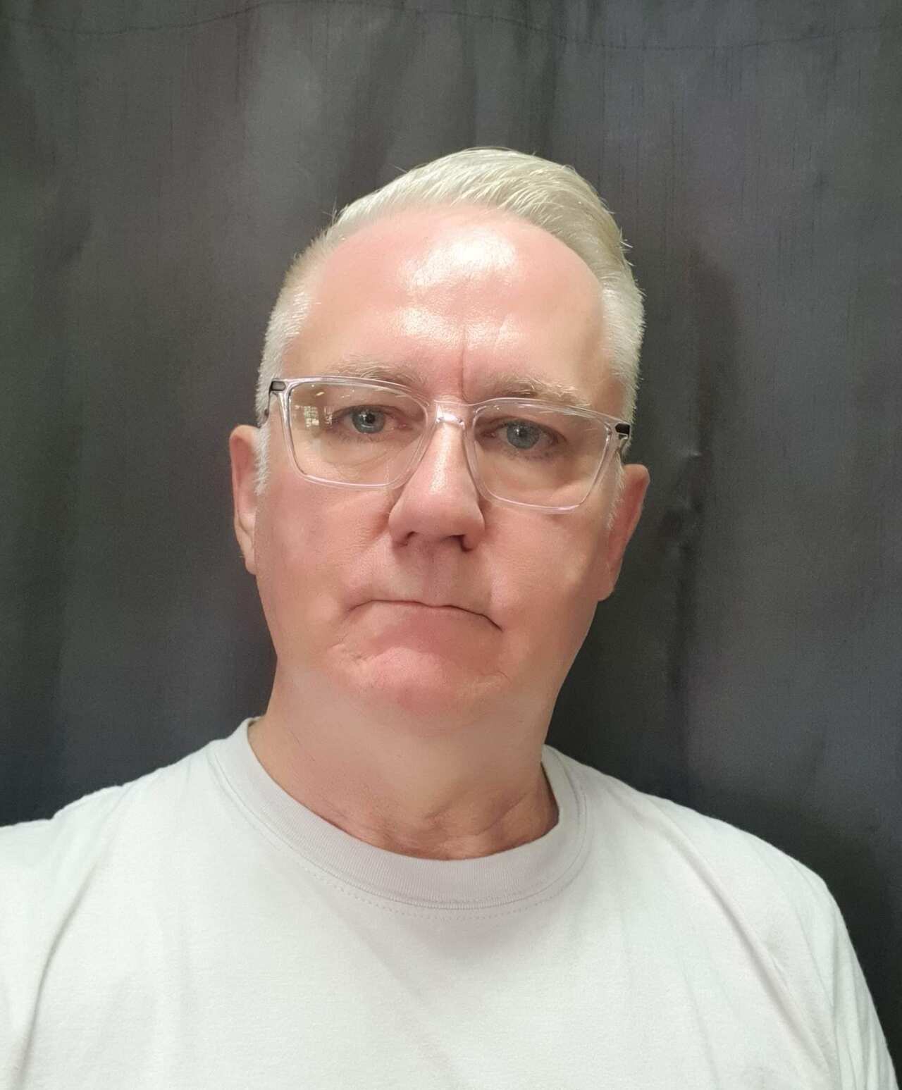 A man wearing a white t-shirt and glasses