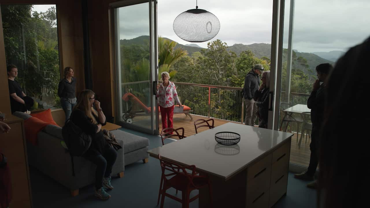 A lady standing in the living room of her house.