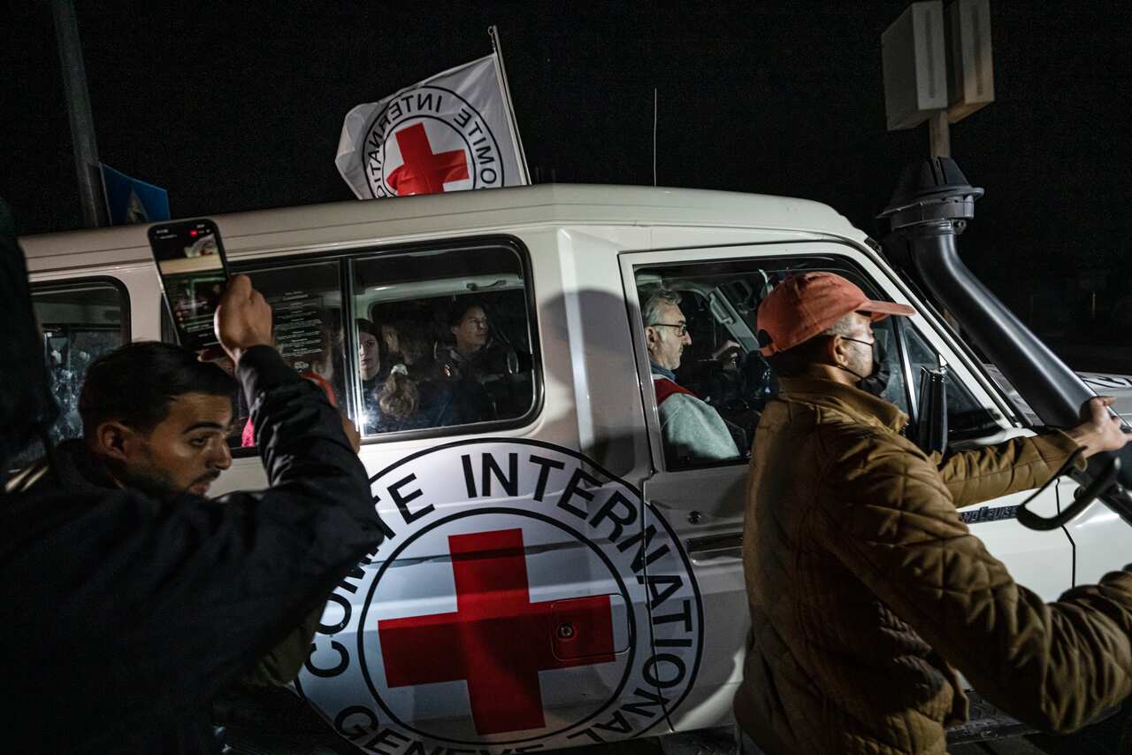 People following a Red Cross vehicle carrying Israeli hostages.