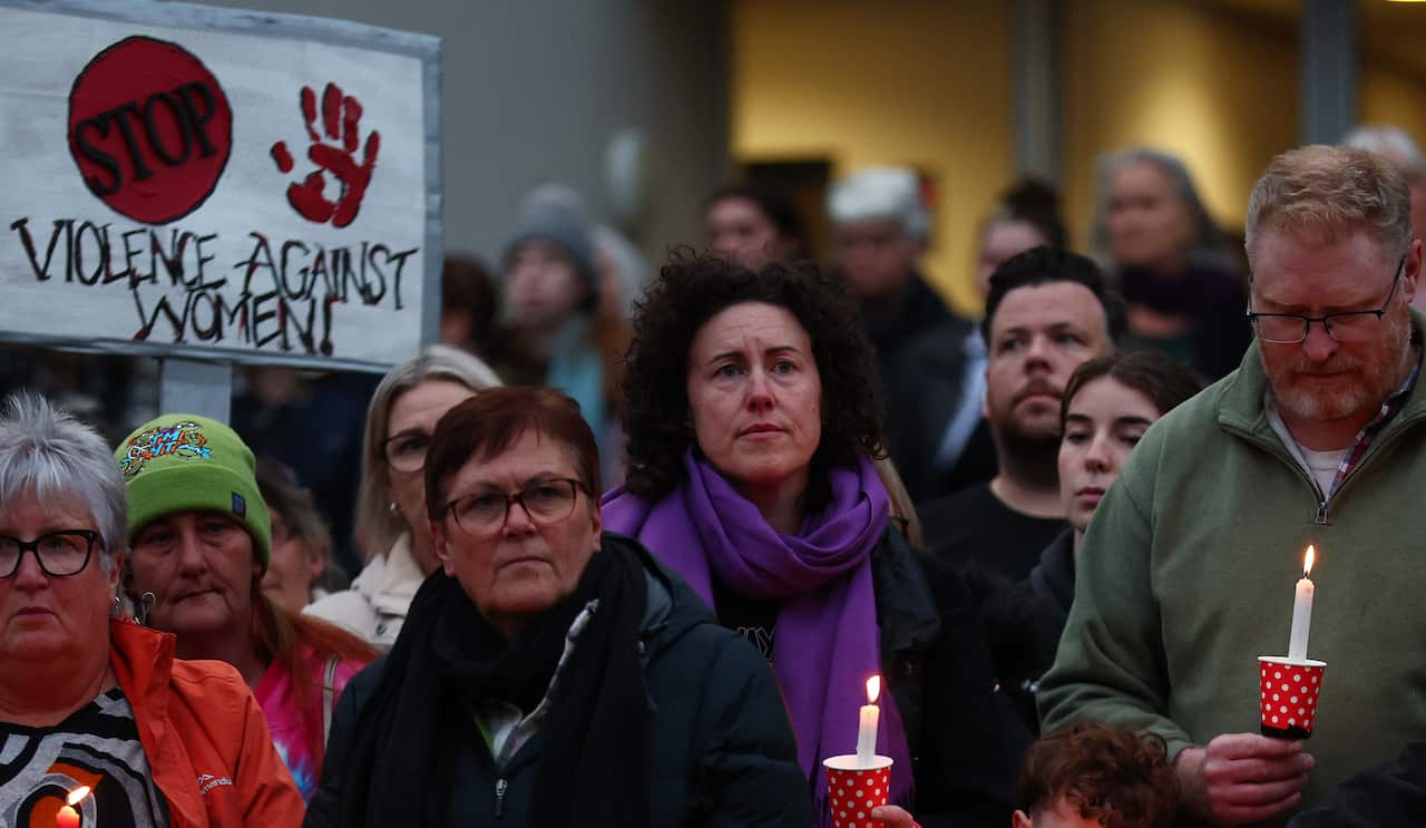 A group of protesters, some holding candles.